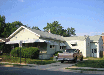 A photograph of a single-family home with a brown truck in front.