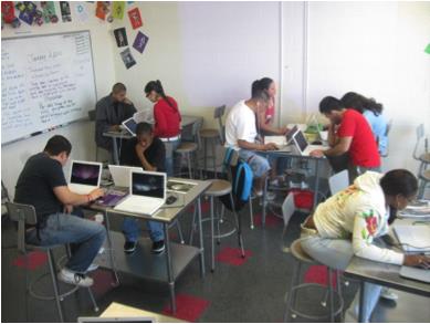 Photograph of nine students working at laptops in a computer lab. 