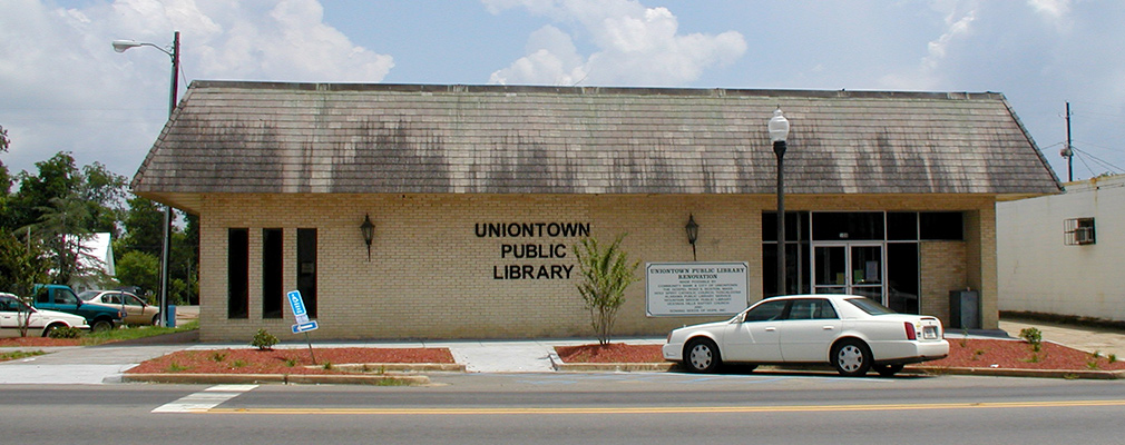 Photograph of a one-story brick office building with a sign reading “Uniontown Public Library.”