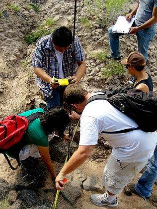 Photograph of five students taking measurements of differences in ground elevation. 