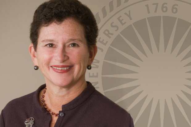 A photograph of Dr. Nancy Cantor with a portion of the Rutgers University seal in the background.