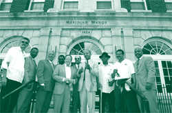 A picture of dignitaries in front of Meridian Manor at its grand opening in 2002.