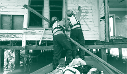 A picture of workers examining the structural soundness of a disaster-damaged property in Galveston, Texas.