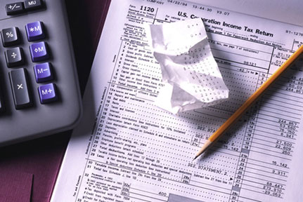 Tax form, calculator and pencil; close-up. 