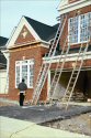 Four ladders leaning against a new two-story brick house