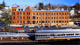 Large brick building and nearby train.
