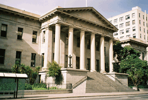 A photograph of a two story stone building with six columns in front.