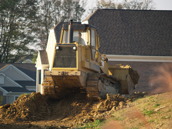 Bulldozer in front of two homes.