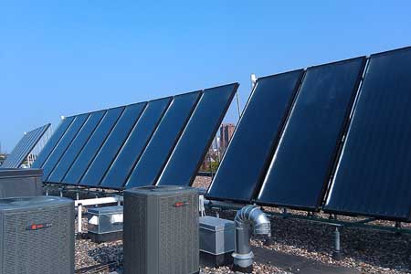 A picture of solar panels on the rooftop of an apartment building. 
Photo credit: Clean Energy Resource Teams via Flickr