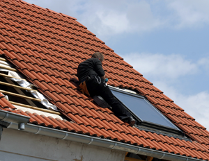 A photo of a worker installing a skylight.