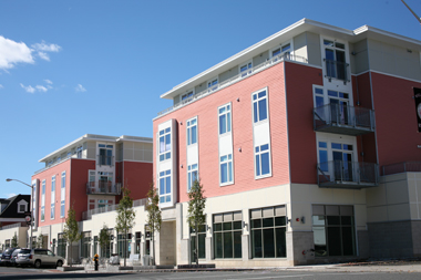 30 Haven, a four-story building, with a façade that differentiates the first-floor commercial space from the residential floors above by means of material, color, and window size and shape — as seen from across the street.